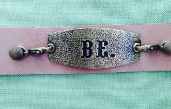 Leather bracelet with a metal plate stamped BE.